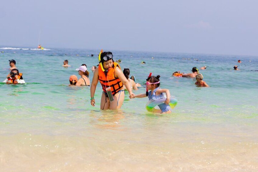 A beach with people swimming and snorkeling. 5