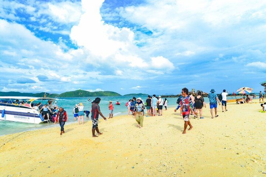 A beach with people walking, a boat, and a clear sky. 3