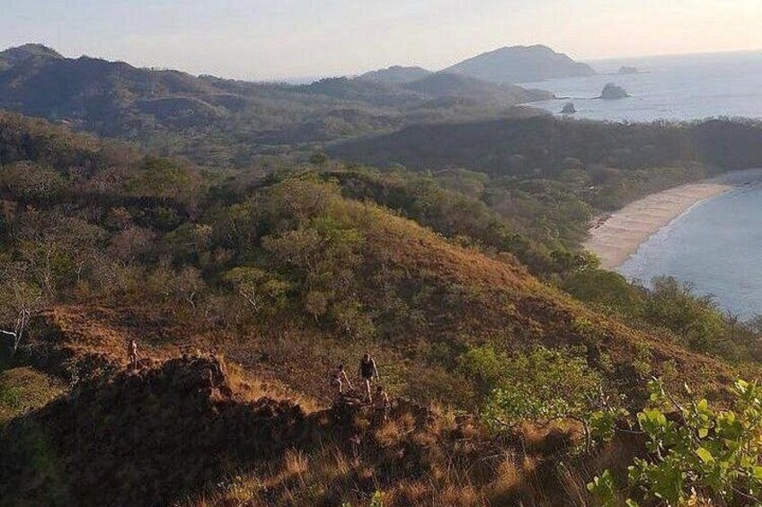 Un paysage côtier avec des collines, une plage et une étendue d’eau. 3