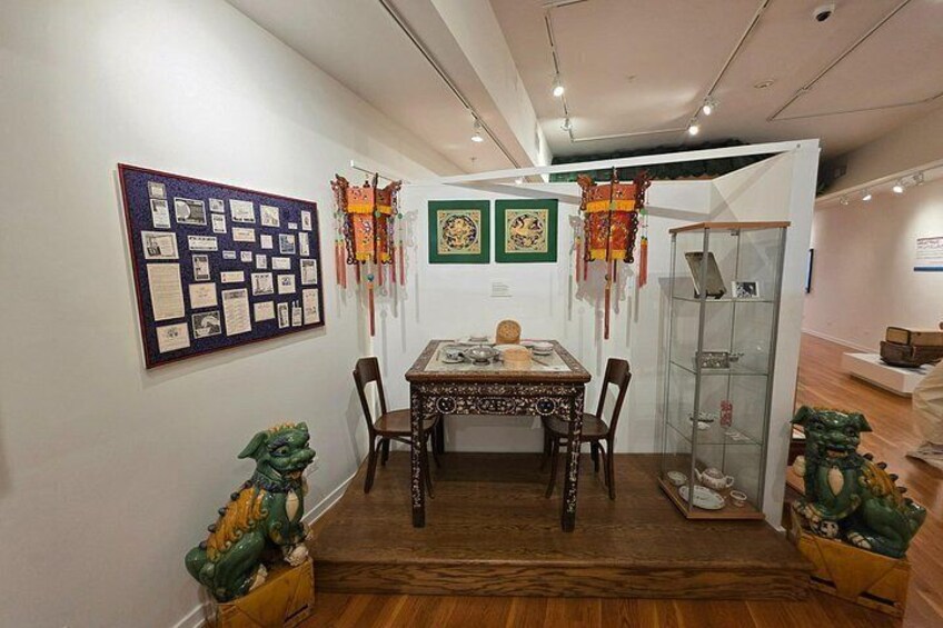 A dining area with a wooden table, chairs, and a decorative wall with framed pictures and a bulletin board. 4