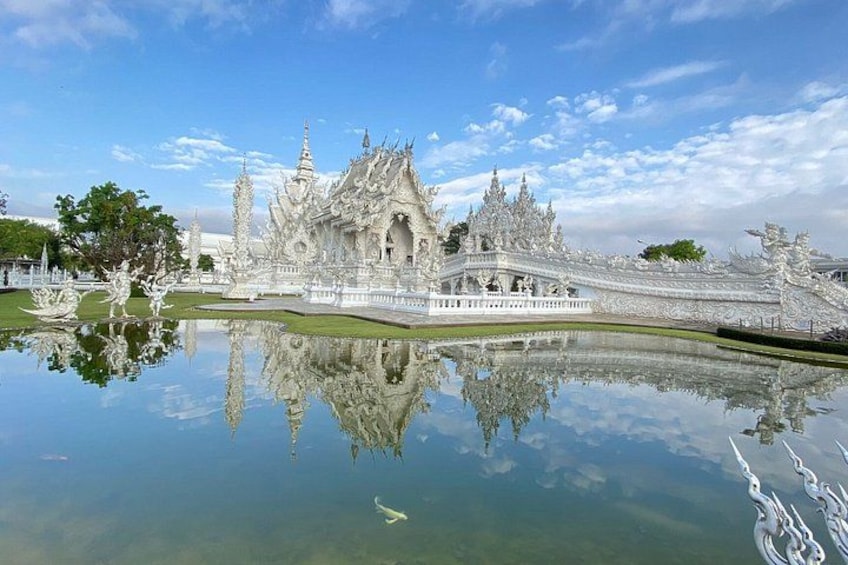A white ornate temple with a reflection in a calm water body. 2