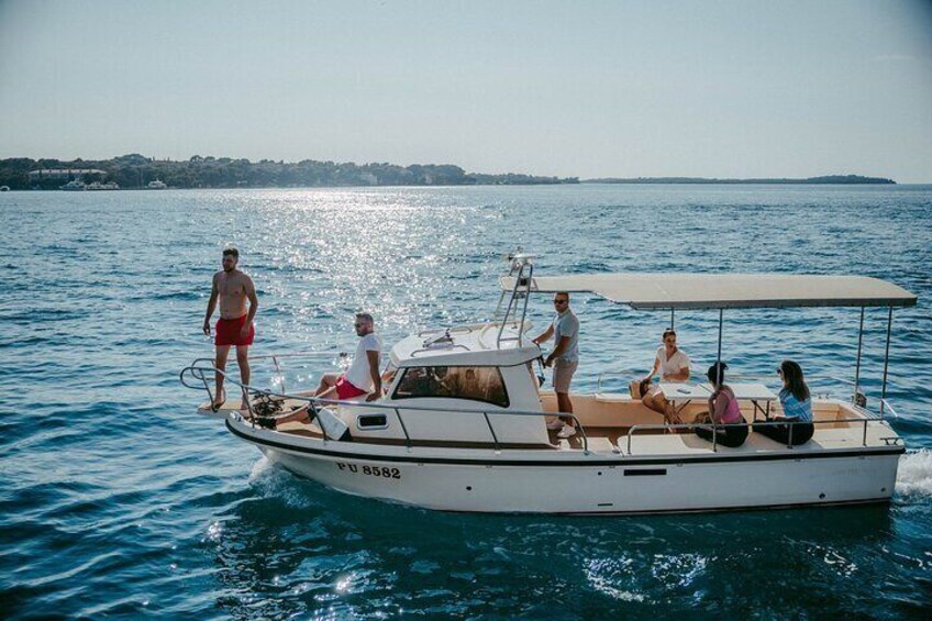 Un barco blanco con gente a bordo, cielo despejado y aguas tranquilas. 4