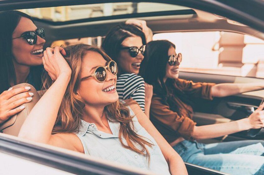 A group of people in a car, with one person driving. 2