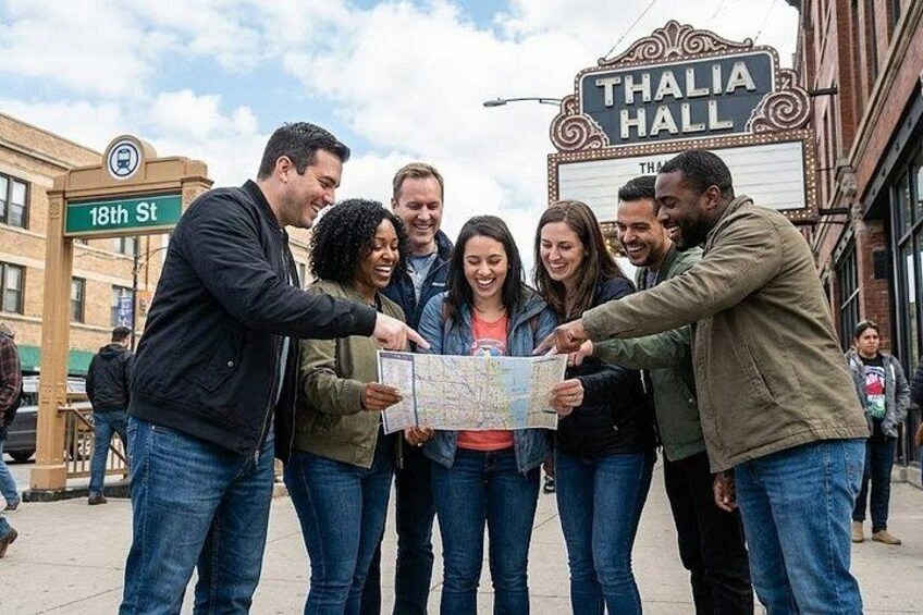 Un groupe de personnes est rassemblé devant le théâtre Thalia Hall et examine une carte. 1
