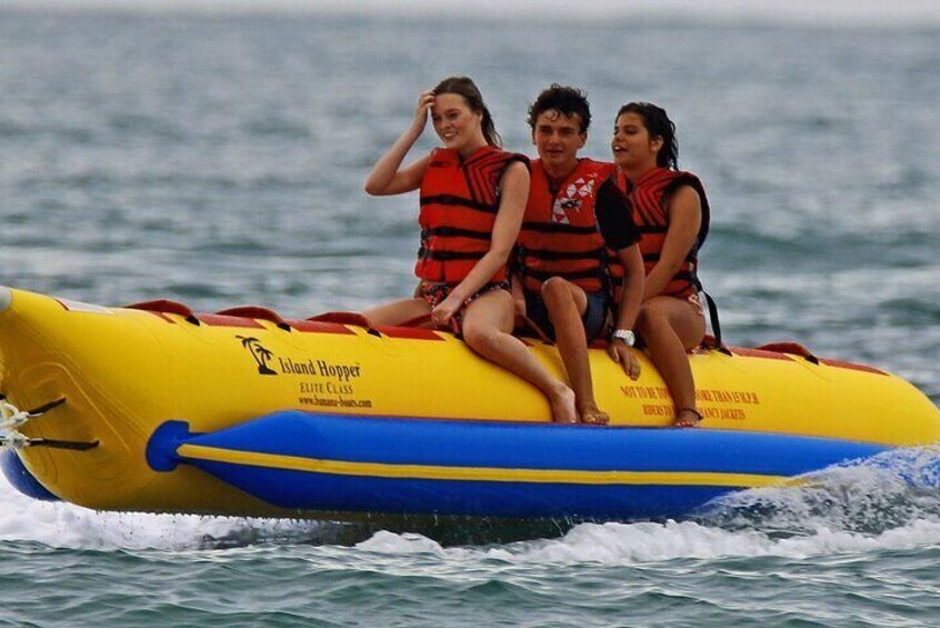 Un bote inflable amarillo y azul con tres personas usando chalecos salvavidas. 5
