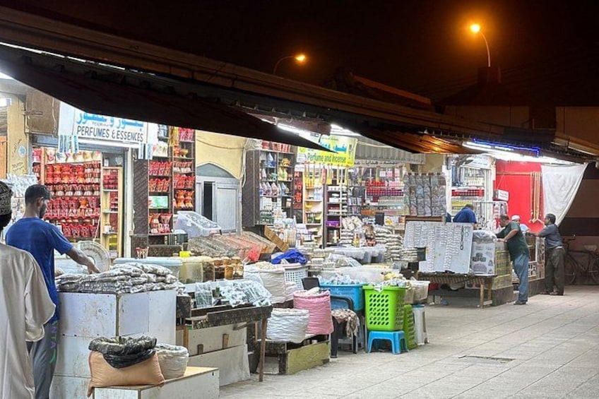 Un marché nocturne où divers stands proposent à la vente une variété de produits, notamment des produits alimentaires et des articles ménagers. 3