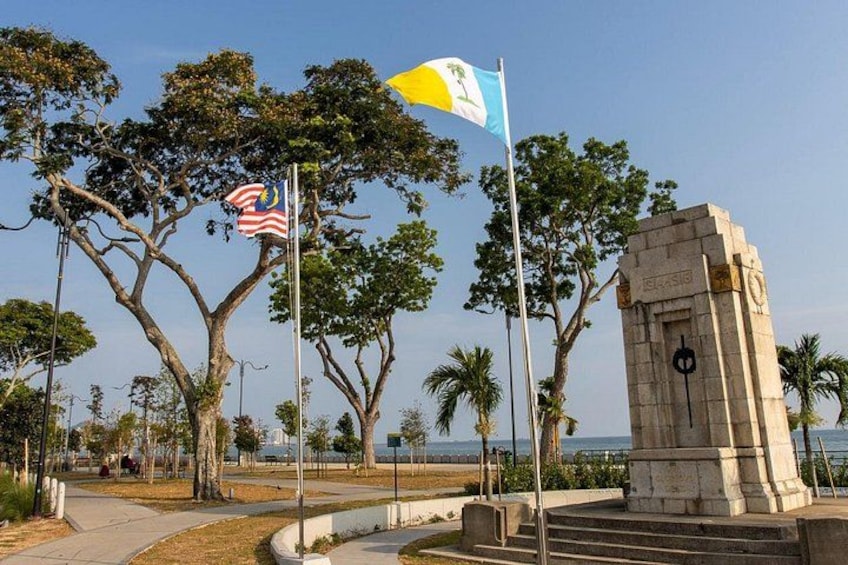 A monument, flags, trees, and a pathway. 4