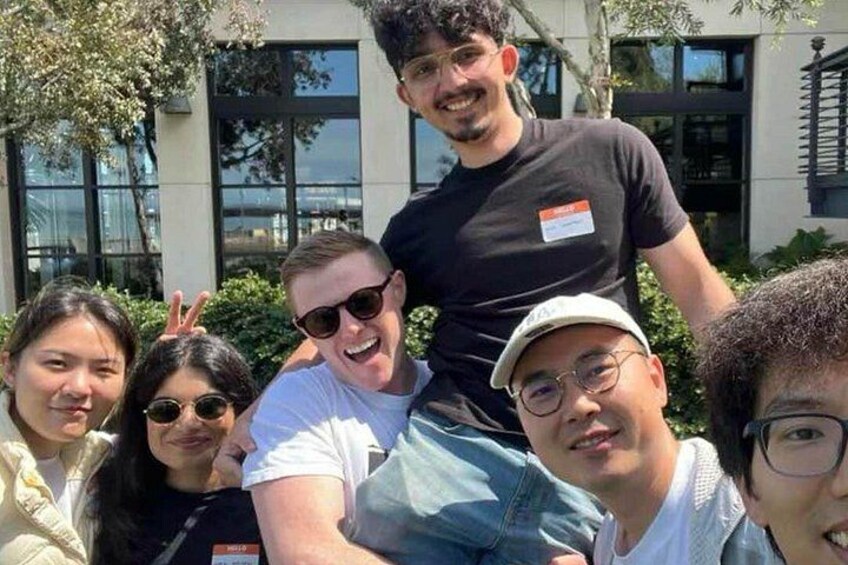 A group of people outdoors with a building in the background. 3