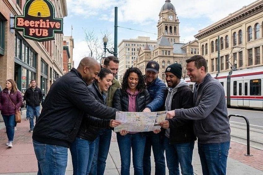A group of people examining a map in front of a building with a sign that reads 'Beerhive PUB'. 1