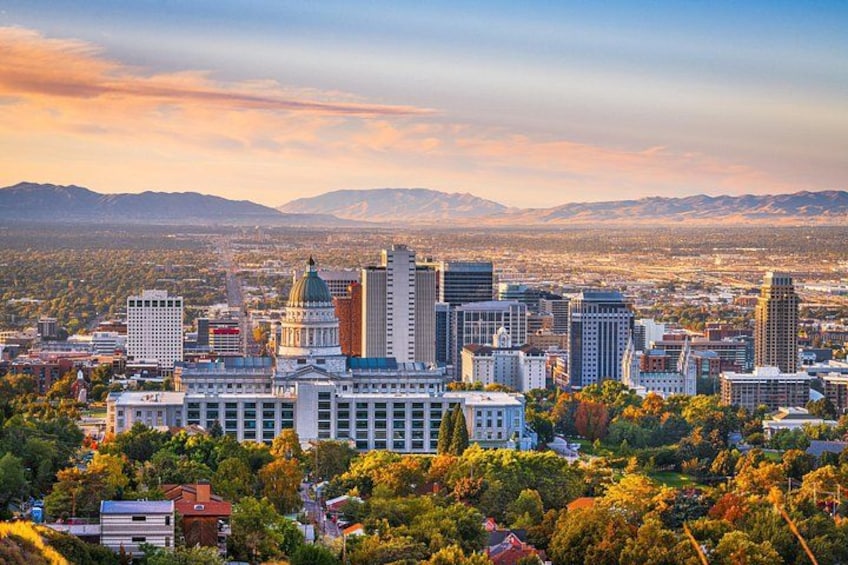 A cityscape with a prominent government building, several high-rise buildings, and a mountainous backdrop. 2