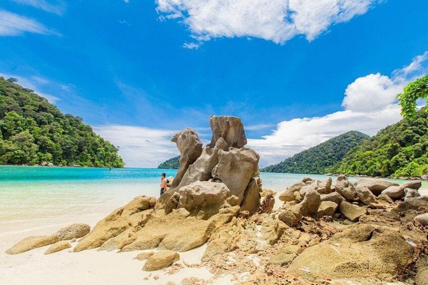 A beach with large rock formations and clear turquoise water. 2