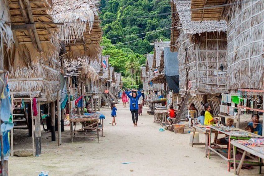 A village with thatched-roof houses, a central pathway, and people engaged in daily activities. 3