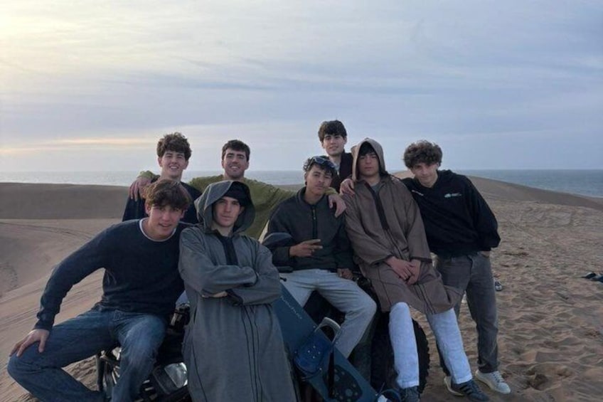 Un gruppo di persone su una spiaggia sabbiosa con l'oceano sullo sfondo. 3