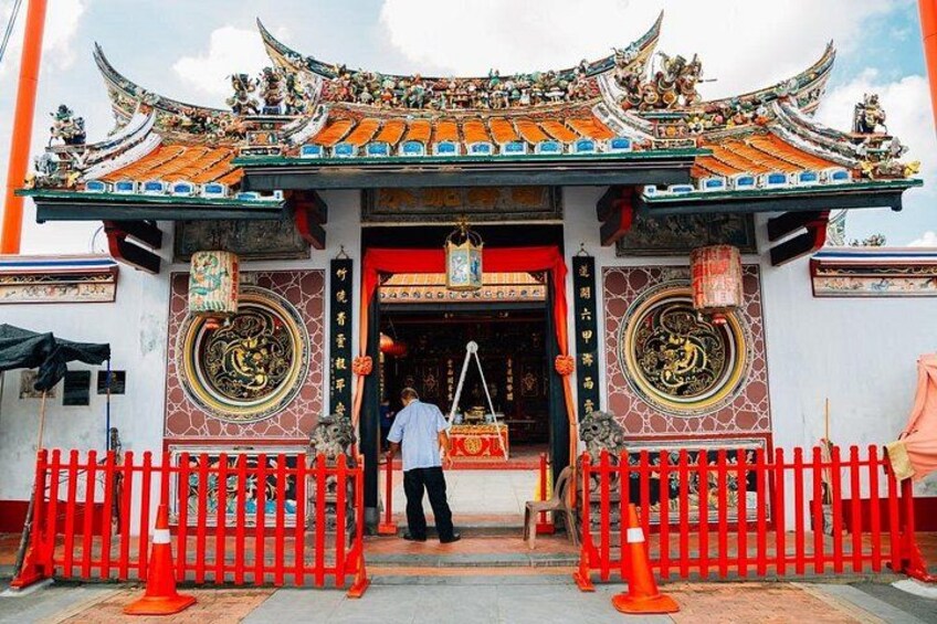 A traditional Chinese temple entrance with ornate decorations and a person standing in front. 2