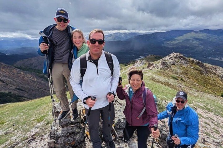 A group of people hiking on a mountain with rocky terrain and a cloudy sky. 3