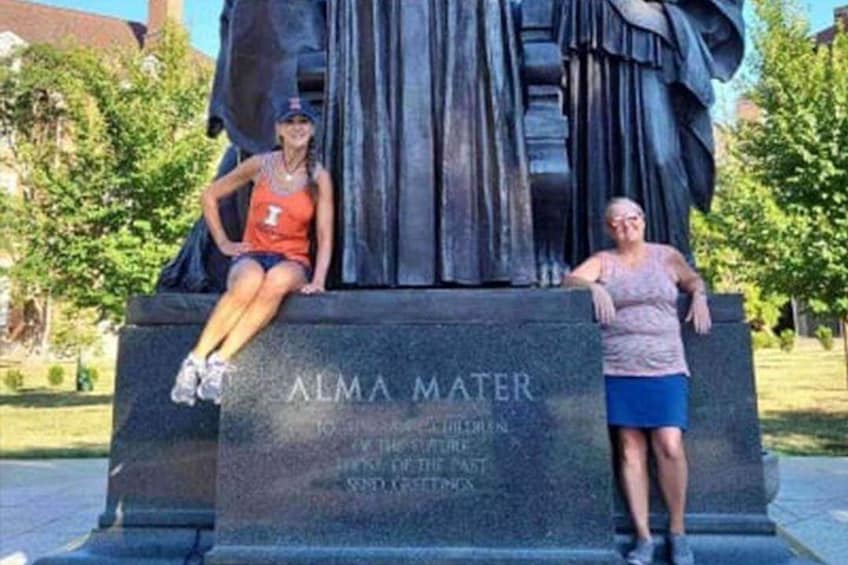 A statue of Alma Mater with two people sitting on it. 2