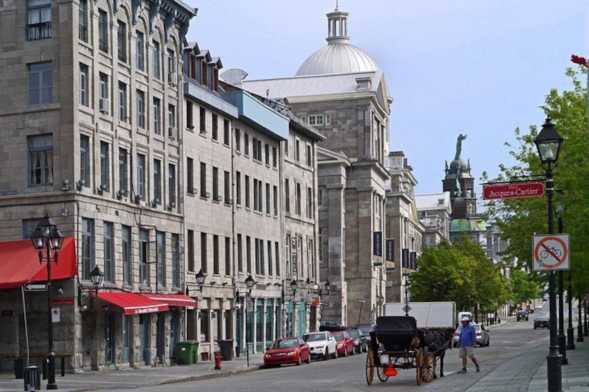 A street with buildings, a horse-drawn carriage, and a no-parking sign. 2