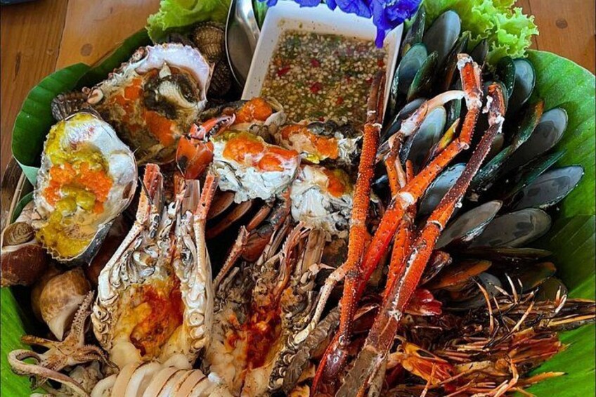 Fisk og skaldyr, herunder krabber, muslinger og østers, anrettet på et grønt blad. 2