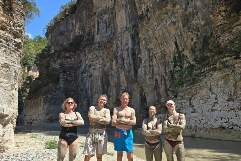 A group of people standing in front of a rocky cliff. 3