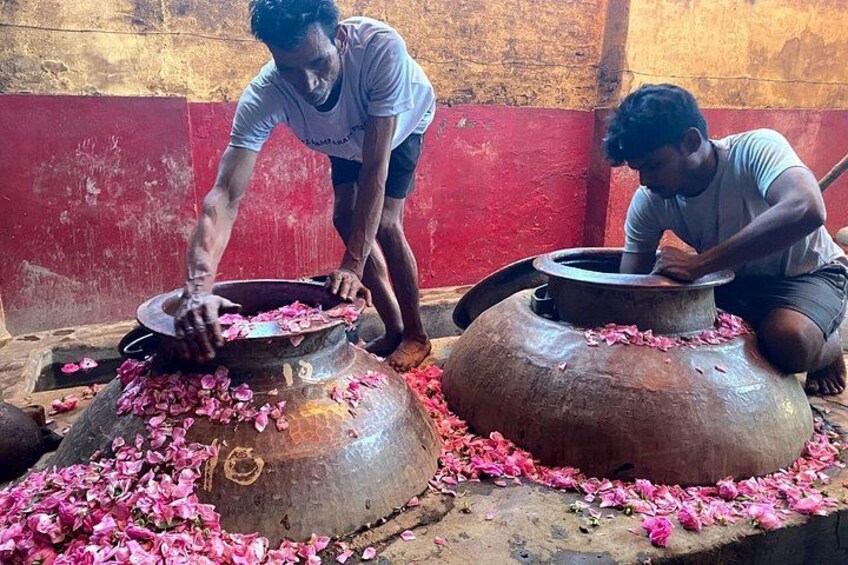 Dos personas trabajando con ollas de metal grandes y pétalos de flores. 3