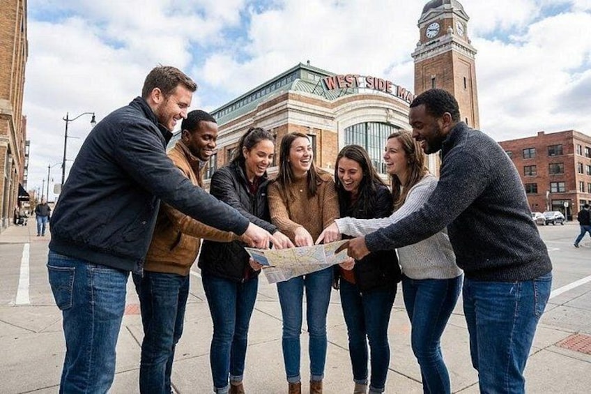 Un grupo de personas revisa un mapa en una calle de la ciudad, con un edificio histórico al fondo. 1