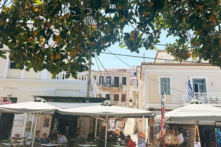 Un mercado callejero con puestos al aire libre, una bandera y edificios al fondo. 5