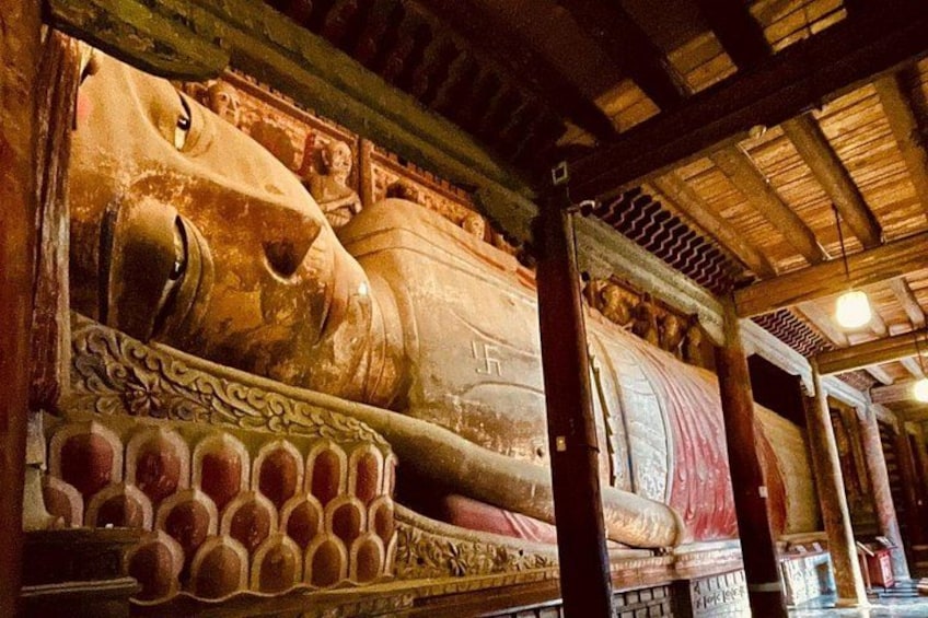 A large, intricately carved sarcophagus with a lion's head, set in a dimly lit room with wooden beams and columns. 4