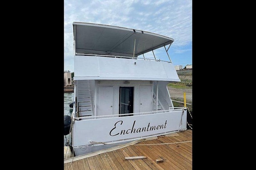 Un barco blanco llamado 'Enchantment' atracado en un muelle de madera. 2