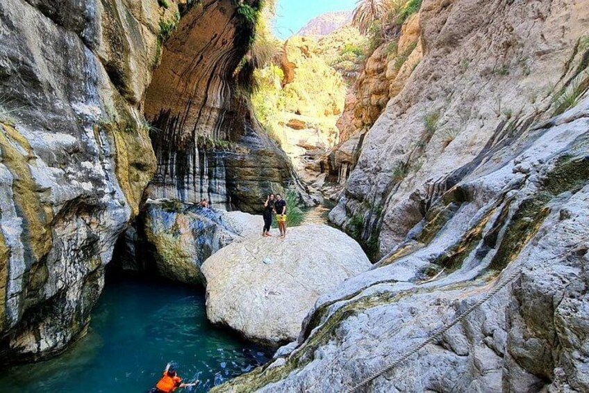 Un cañón con un estrecho canal de agua, terreno rocoso y una persona en kayak. 1