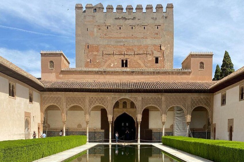 A historic building with a courtyard, arched walkways, and a central fountain. 1
