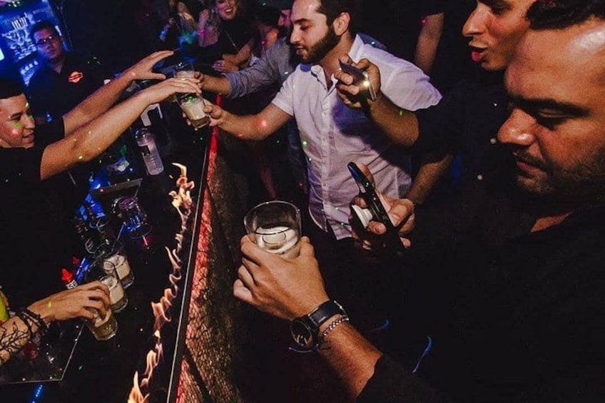 Escena de bar con gente sosteniendo bebidas y vasos. 3