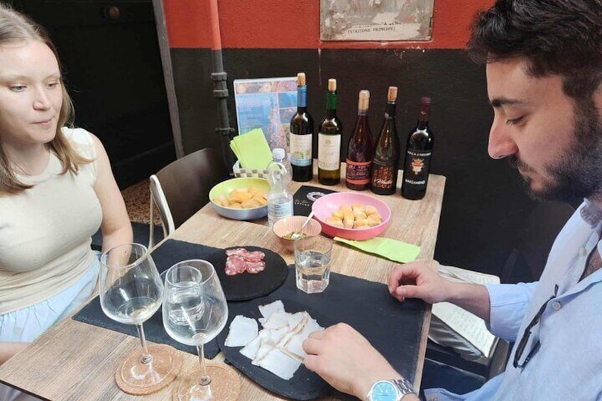 A dining table with wine bottles, glasses, and plates of food. 1
