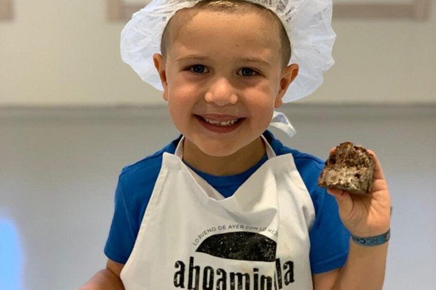 Una persona con gorro y delantal de chef, sosteniendo un alimento. 3