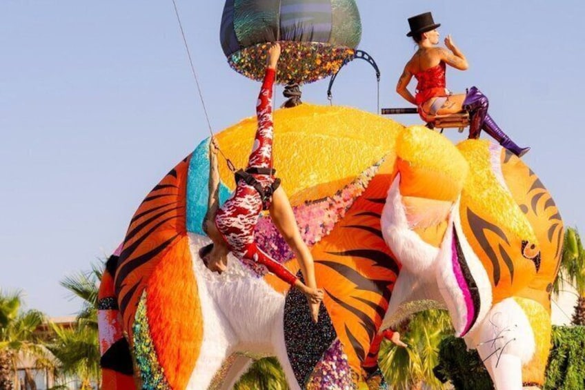 A person performing on a large, colorful elephant sculpture. 4