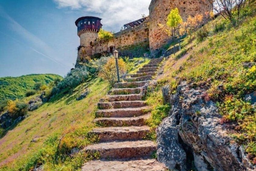 A stone staircase leading up a hill with a castle in the background. 4