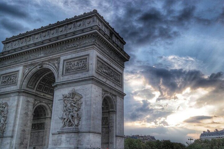 The Arc de Triomphe in Paris with intricate carvings and a cloudy sky. 4