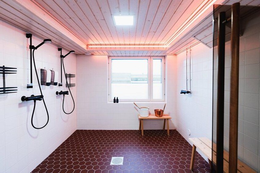 A room with a hexagonal patterned floor, a window with blinds, and a wooden bench. 2