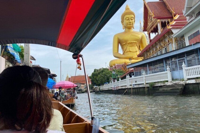 Eine große goldene Buddha-Statue, ein Boot und ein traditionelles thailändisches Gebäude mit rotem Dach. 1