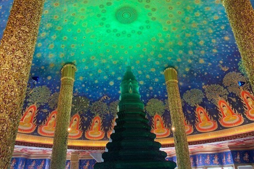 Der Innenraum eines Tempels mit aufwendigen Säulen, einer zentralen Stupa und detaillierten Wandmalereien. 4