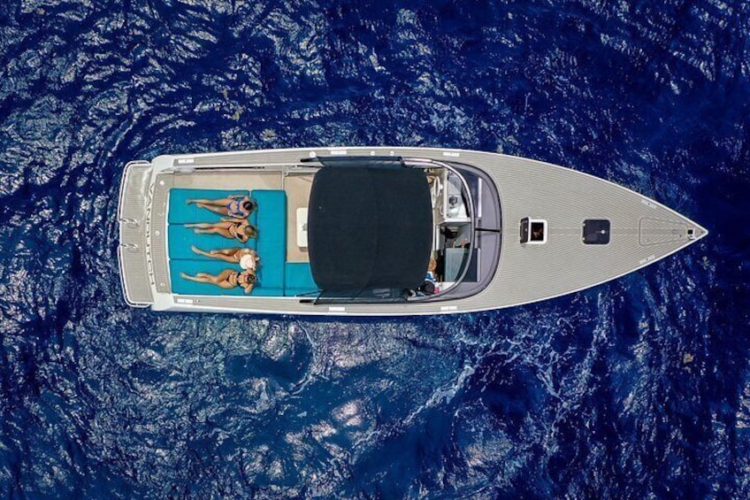 A small boat with a blue deck and a person lying on it. 3