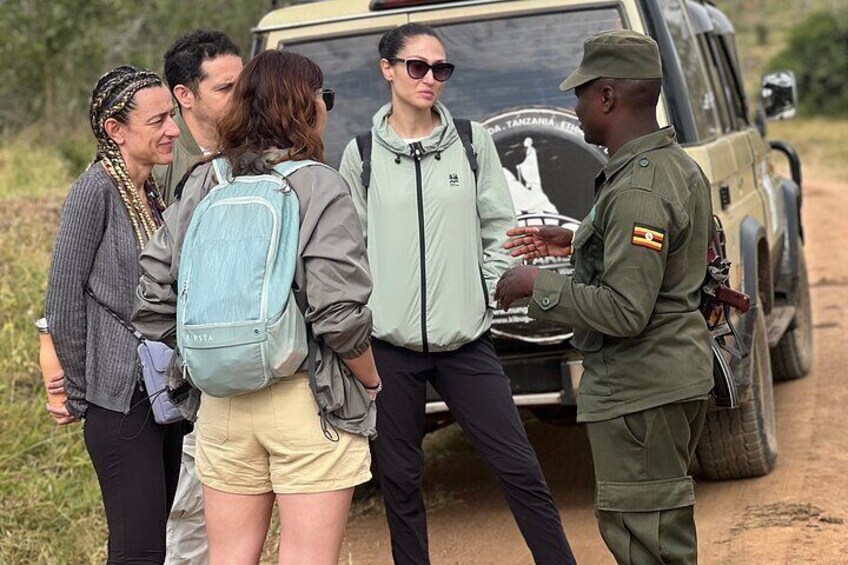 A group of people standing by a vehicle with a map on the back window. 4