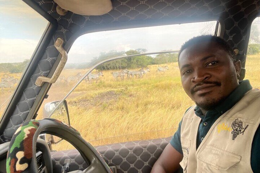 A person inside a vehicle with a steering wheel and a seatbelt. 3