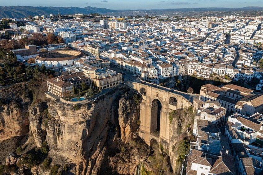 A coastal city with a prominent historical bridge and a fortified building. 4