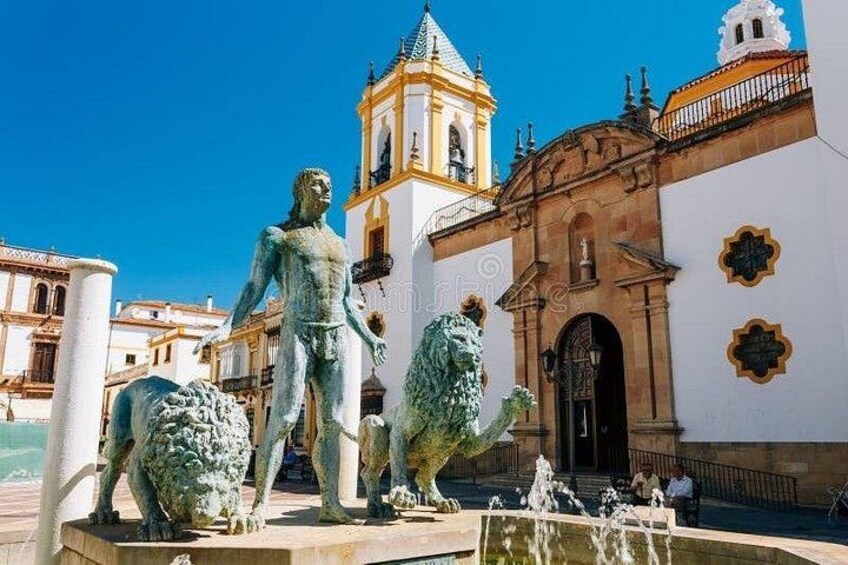 A statue of a man with a lion, a fountain, and a church with a bell tower. 2