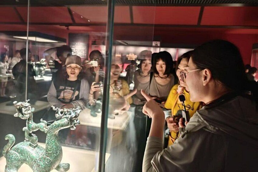 A person speaking to a group of people in a room with a glass partition. 3