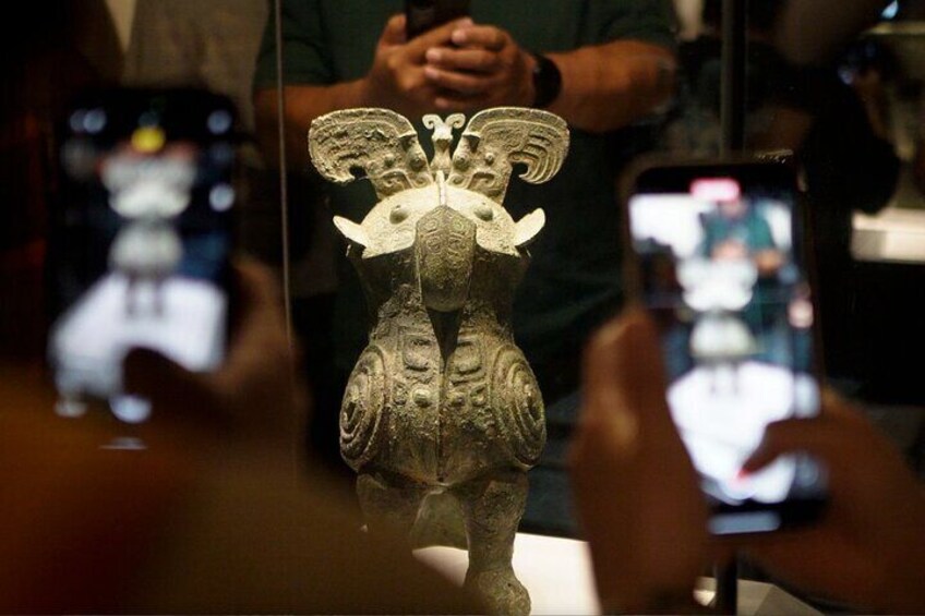 A detailed sculpture of a mythical creature with wings, displayed in a museum. 1
