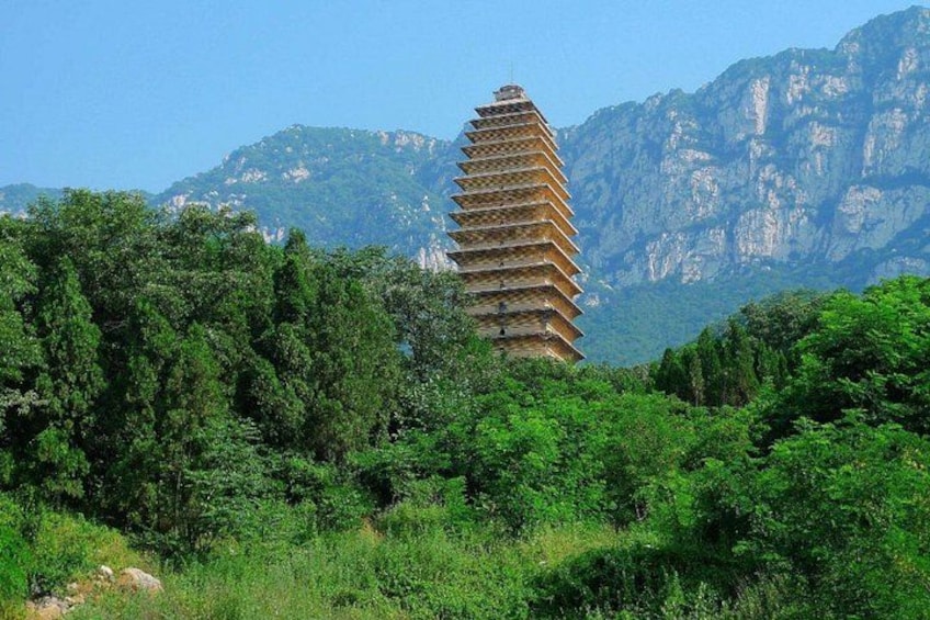 A pagoda-like structure surrounded by lush greenery and mountains in the background. 5