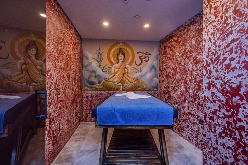 A room with a mural of a meditating figure, a blue mat, and a patterned wall. 2