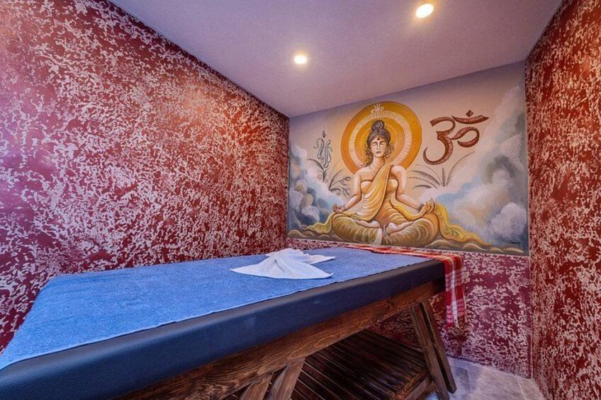 A room with a mural of a meditating figure, a bed, and a wall with a textured pattern. 3