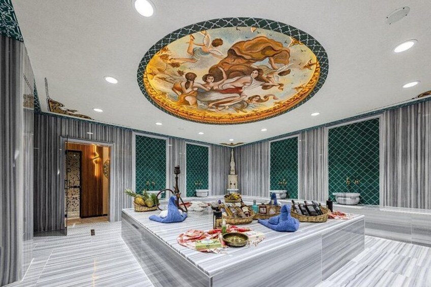 A luxurious room with a marble floor, a central table with fruits and a decorative item, and a ceiling mural. 1